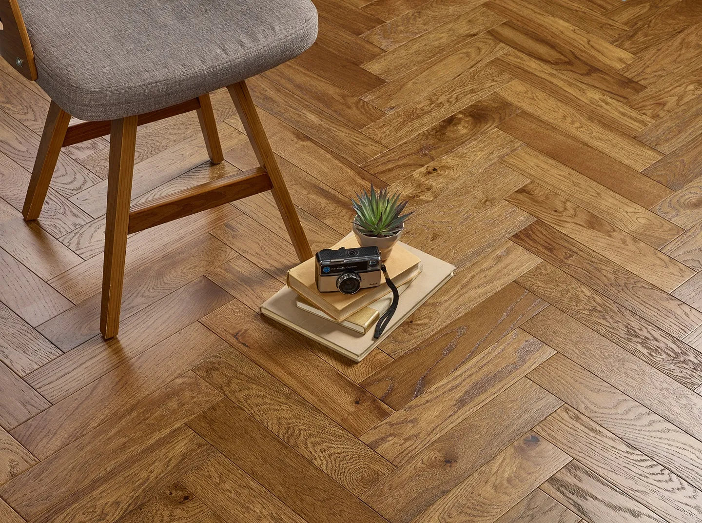 Cognac brushed and lacquered oak engineered wood flooring in elegant herringbone design.