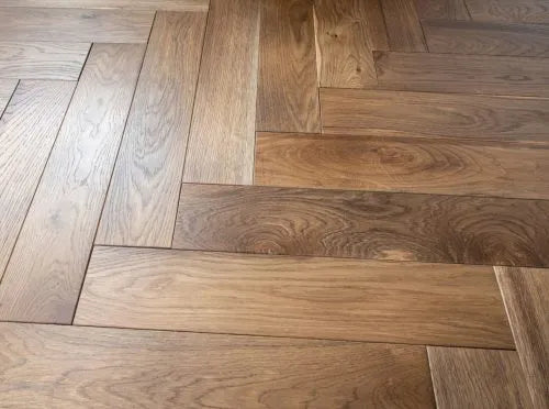 Herringbone smoked oak flooring with brushed grain and micro-bevelled edges for seamless fit.