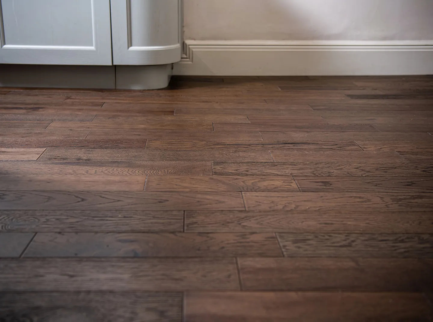 Black washed brushed and lacquered engineered wood flooring with rich oak grain detail.