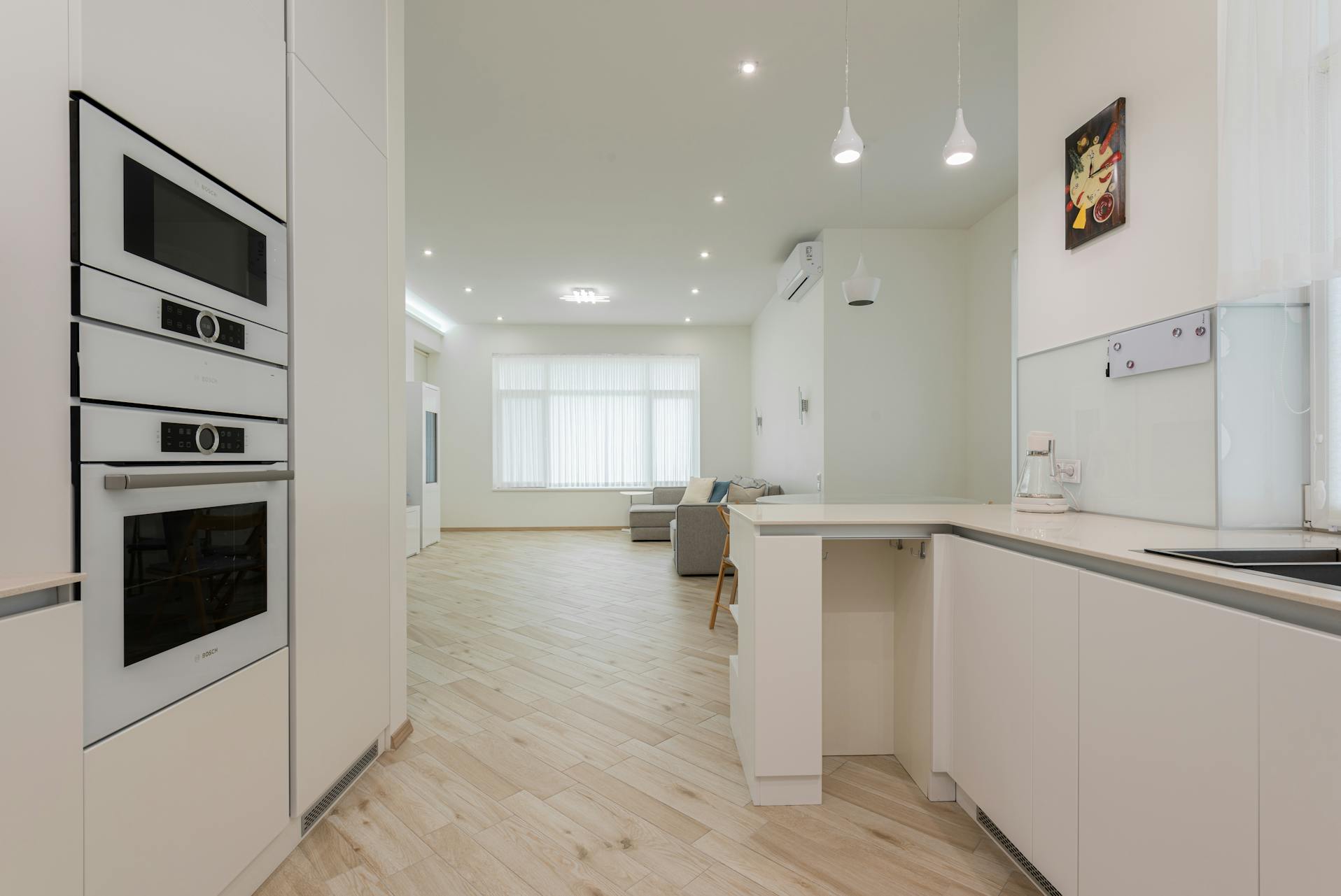 Interior design of luxury house having white paint on walls and teak wood decking on floor.